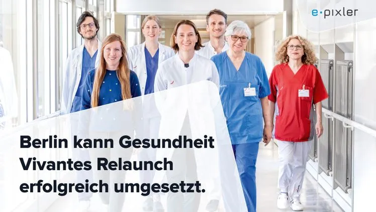 Sieben medizinische Fachkräfte in weißer und bunter Arbeitskleidung gehen freundlich einen Krankenhausflur entlang