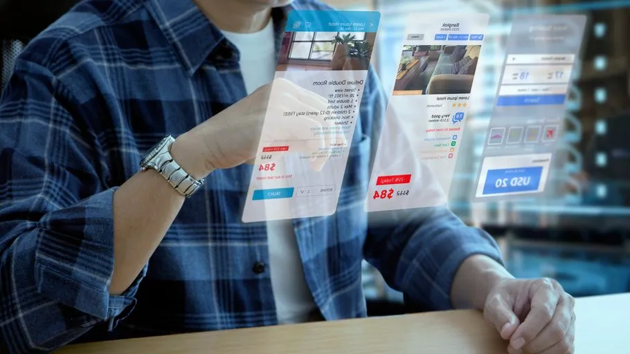 Mann in Freizeitkleidung bei der Interaktion mit einem futuristischen virtuellen Bildschirm einer Anwendung zur Hotelreservierung und Reiseplanung
