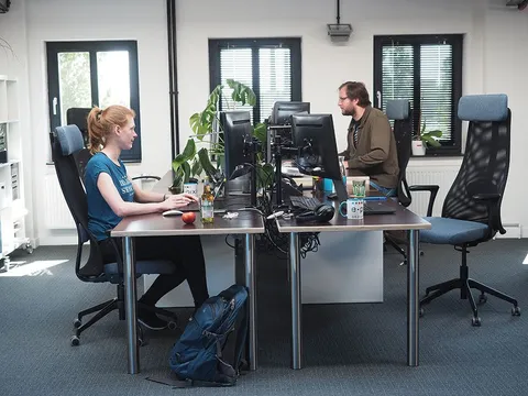 Zwei Mitarbeiter bei e-pixler arbeiten an ihren Schreibtischen in einem modernen Büro.