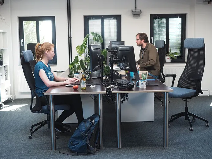 Zwei Mitarbeiter bei e-pixler arbeiten an ihren Schreibtischen in einem modernen Büro.