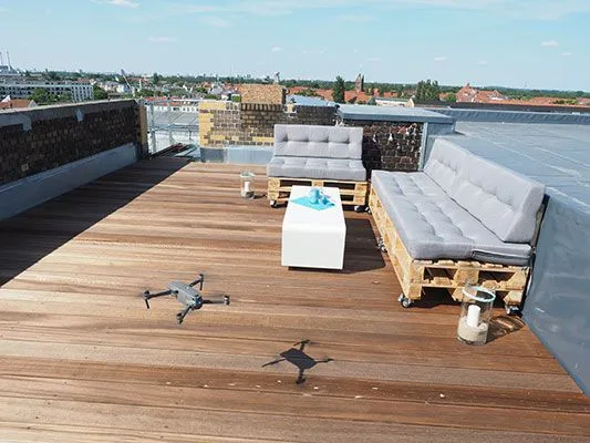 Drohnen auf der Dachterrasse bei e-pixler mit Sitzmöbeln und Blick auf die Stadt.