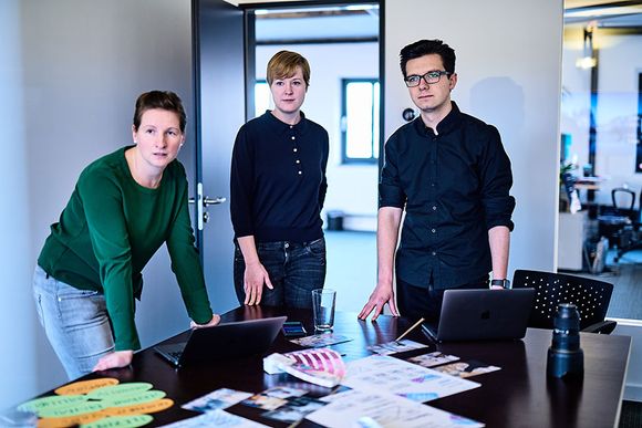 Drei UX-Designer bei e-pixler arbeiten gemeinsam an Konzepten und Strategien für eine verbesserte Benutzererfahrung.